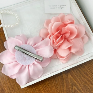 Barrettes élégantes avec fleurs en tissu rose et pétales sur une table en bois rustique