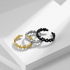 Detail van verstelbare sterringen in goud, zilver en zwart met kleine kristallen steentjes