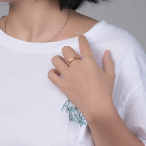 Detail van een gouden sterrenring met glanzende zirkonia aan de hand van een model