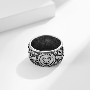 Close-up of vintage sun and moon relief carvings on a wide titanium steel ring