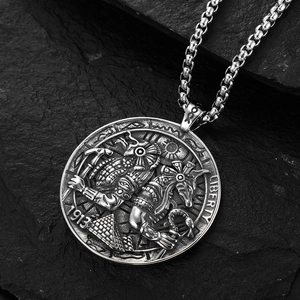 Collier pièce égyptienne Anubis vintage en acier inoxydable sur fond de roche