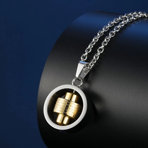 Detail of rotating gold cylinder with engraved Bible verses on stainless steel pendant