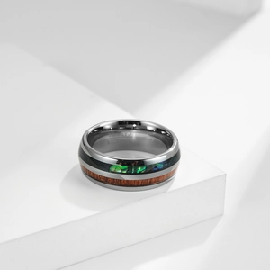 Wolframcarbid Ring mit Holz-Inlay und Abalone-Muschel auf weißem Ständer poliert