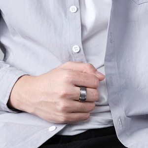 Men's minimalist wide tungsten steel ring with brushed silver finish on a male hand