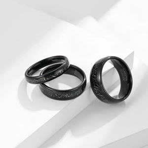 Macro shot of black tungsten rings with silver scratch texture on white geometric stand