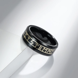 Men's black tungsten ring featuring golden Nordic runes on white geometric display