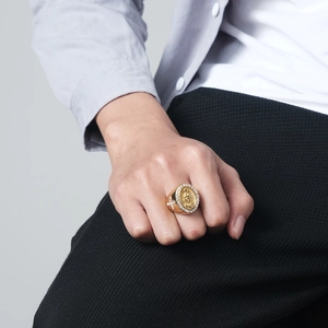 Golden hip hop ring featuring Virgin Mary portrait and iced out cross on model hand