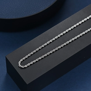 Collier chaîne de corde en acier inoxydable argenté poli sur un présentoir à bijoux chic