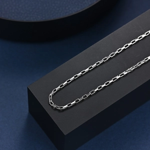 Collier chaîne box en acier inoxydable argenté poli sur un présentoir de luxe