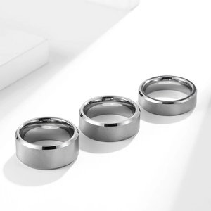 Detail of matte brushed tungsten steel rings with polished edges on white geometry background