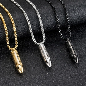 Détail de pendentifs en forme de balle avec gravure de croix en or, argent et noir