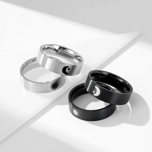 Detailed view of matte black and silver steel rings with sun and moon engravings