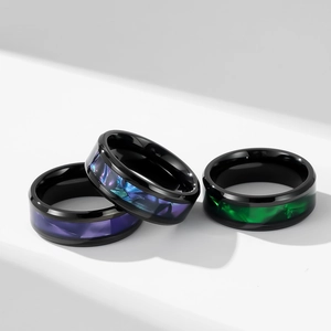 Lot de trois bagues en acier titane noir avec incrustations de nacre violette et verte