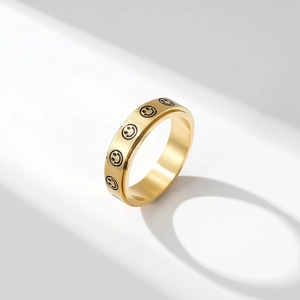 Rotating stainless steel spinner ring with engraved smile faces and brushed gold finish