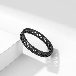 Bague cœur évidé en acier inoxydable noir mat sur un socle géométrique blanc