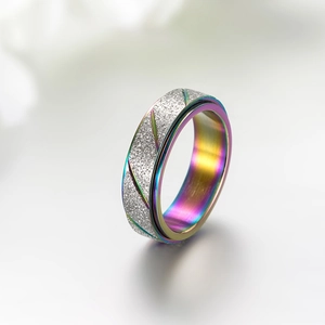 Detail van de draaiende titanium ring met zilveren gezandstraalde textuur en regenboogband