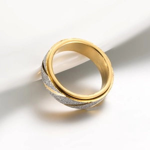 Detailweergave van de tweekleurige roterende ring met goudlaag en zilveren matte textuur