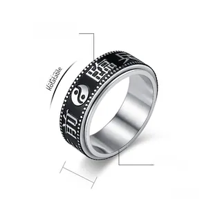 Macro detail of 8mm rotating stainless steel ring with engraved Chinese Taoist symbols