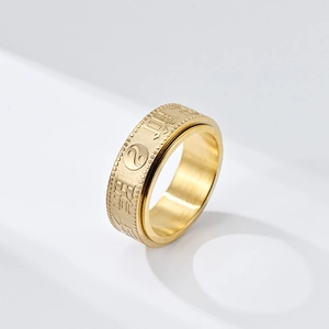 Macro view of gold spinning ring with engraved Chinese characters and Tai Chi symbol