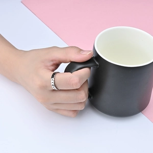 Silver olive leaf stainless steel ring with triangular textures on a hand