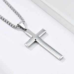 Detailed close-up of polished silver cross pendant with elegant metal bead chain