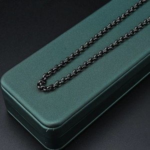 Minimalist black stainless steel chain necklace presented on a dark green jewelry gift box
