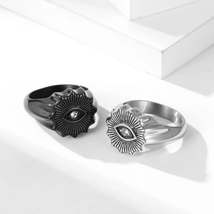 Detail shot of vintage stainless steel evil eye rings with zircon and sunray texture