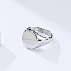 Macro view of a polished stainless steel signet ring with a flat circular face finish