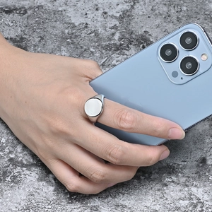 Close-up of a silver stainless steel round signet ring on finger with a casual background