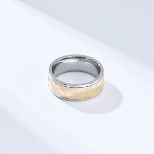 Détail de la texture alvéolée dorée et de la bague de football rotative bicolore en acier