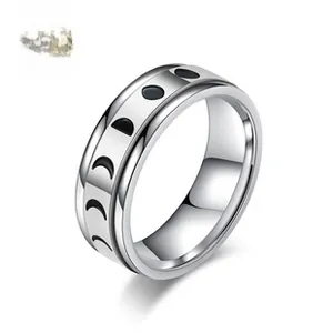 Macro shot of stainless steel spinner ring featuring engraved moon phase cycle patterns