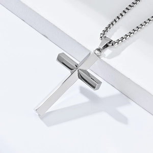 Polished silver stainless steel diamond cross pendant necklace on geometric stand