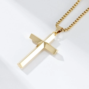 Detailed view of 3D diamond-cut gold stainless steel cross pendant on bead chain