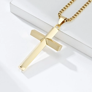 Minimalist gold faceted stainless steel cross pendant necklace on white geometric base