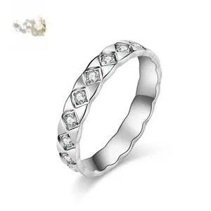 Detailed macro view of silver quilted pattern ring band with sparkling round diamonds