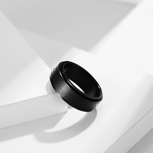 Minimalist black stainless steel rotatable spinner ring for anxiety relief on white background