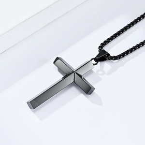 Close-up of a minimalist black stainless steel cross pendant with a matching box chain