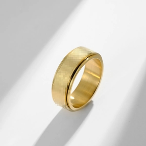 Minimalist gold double-layer spinner ring for stress relief on a white background