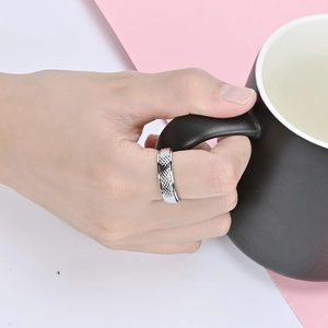 Dettaglio dell'anello rotante in acciaio argentato con motivo a diamante sul dito