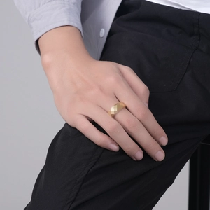 Minimalist gold stainless steel spinner ring worn on index finger for men and women