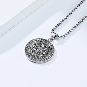 Macro shot of silver Libra zodiac round pendant with micro-paved diamonds on square chain