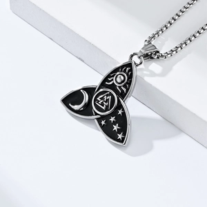 Macro shot of Viking pendant featuring sun, moon, stars and Odin knot in polished steel