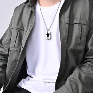 Men's silver dog tag necklace with hollow cross pendant worn over a green cargo shirt