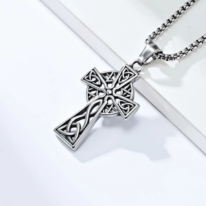 Macro detail of Nordic Celtic cross pendant with triquetra knots on a silver box chain