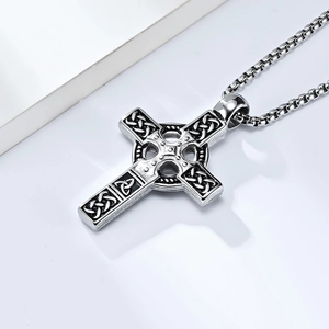 Detailed macro view of a silver Celtic cross pendant with intricate knotwork and box chain