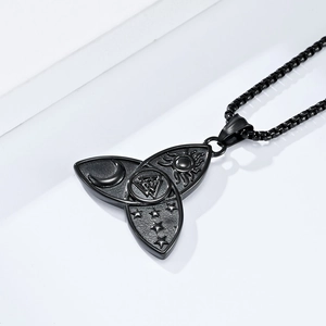 Macro detail of black stainless steel pendant with celestial sun moon and star engravings