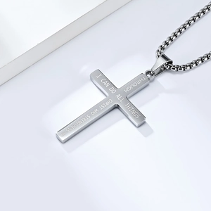 Macro shot of stainless steel cross pendant featuring engraved religious scripture and box chain