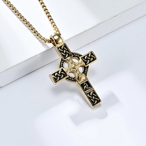 Close-up of golden Celtic cross pendant with intricate knot patterns and square bead chain