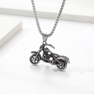 Macro detail of retro skull motorcycle pendant with textured silver engine parts and box chain
