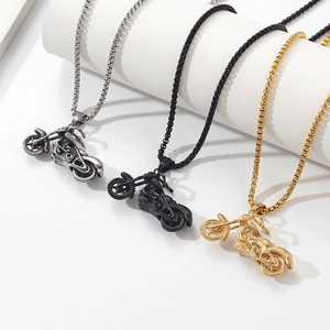 Detail of three-color motorcycle necklaces in silver, black and gold on a white pedestal
